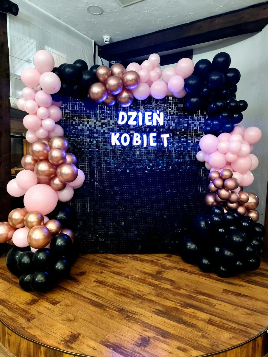 Czarna ścianka pajetkowa na Dzień Kobiet z różowo-czarnymi balonami
