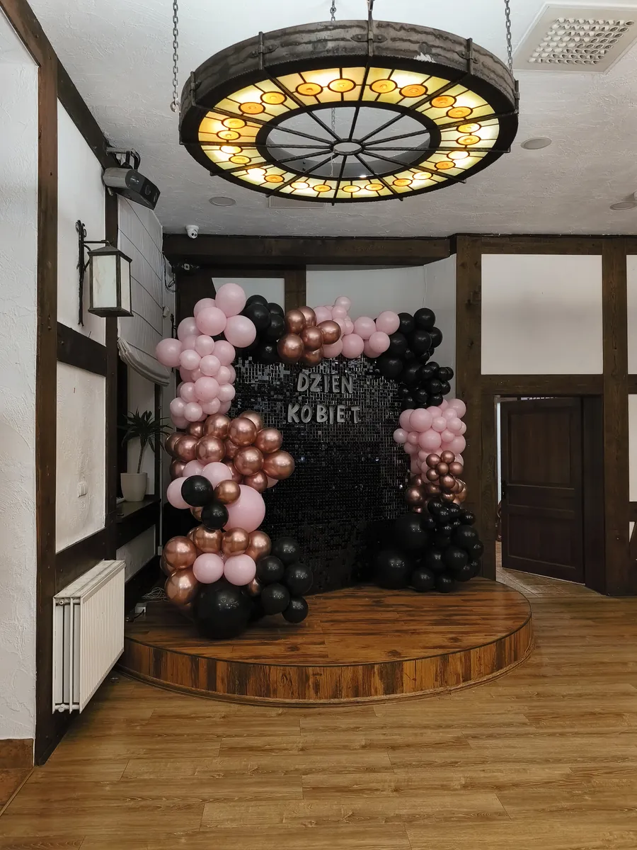 Czarno-różowa ścianka balonowa na scenie pod witrażem