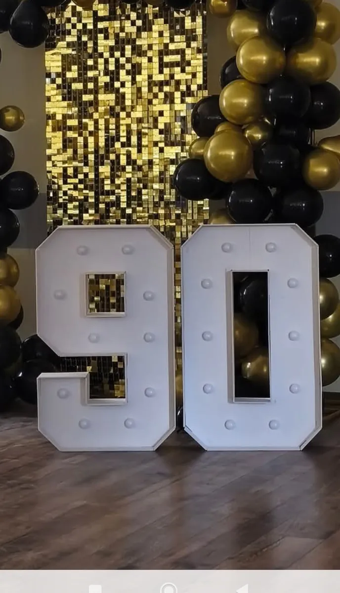 Złota ścianka pajetkowa z podświetlaną cyfrą 90 i balonami